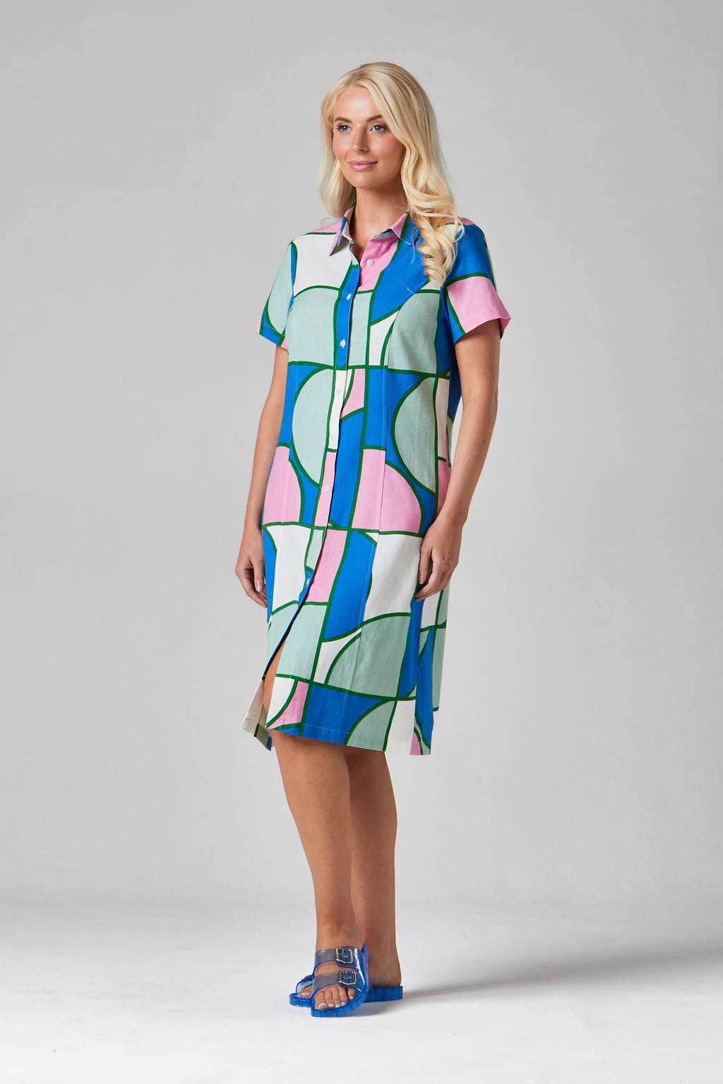 Buy Rosa Shirt Dress Online Alice Collins - Woman wearing a colorful patterned dress on a plain background